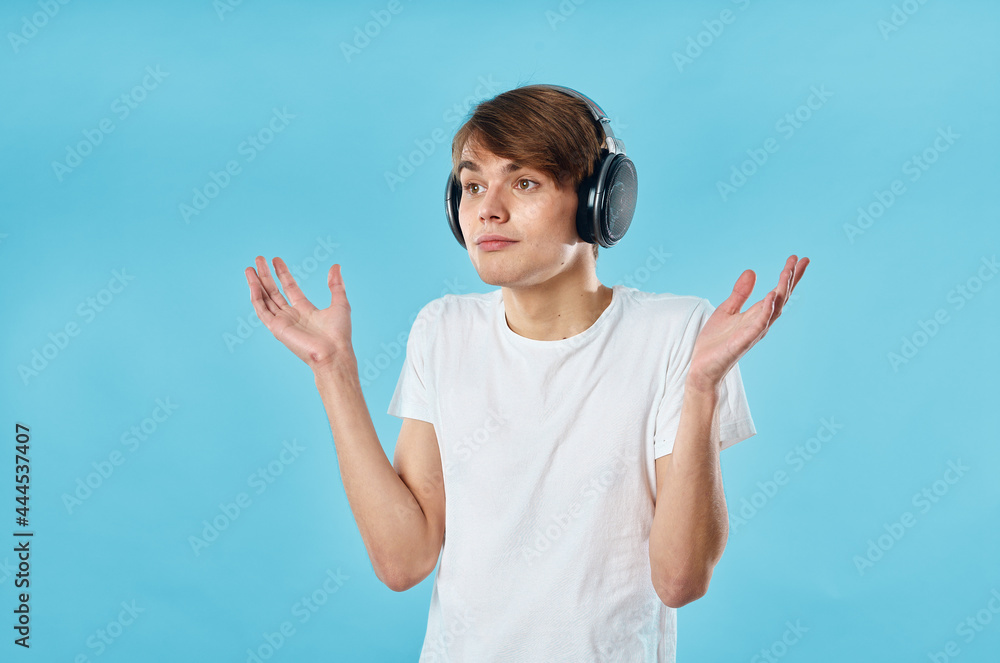 guy in white t-shirt wearing headphones emotions music technology blue background guy in white t-shirt wearing headphones emotions music technology blue background