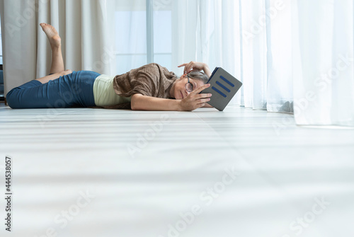 middle aged woman reading a e book © katiekk2