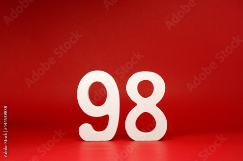 Ninety Eight ( 98 ) white number wooden on Red Background with Copy Space - New promotion 98% Percentage , Birthday anniversary , Business finance Concept 