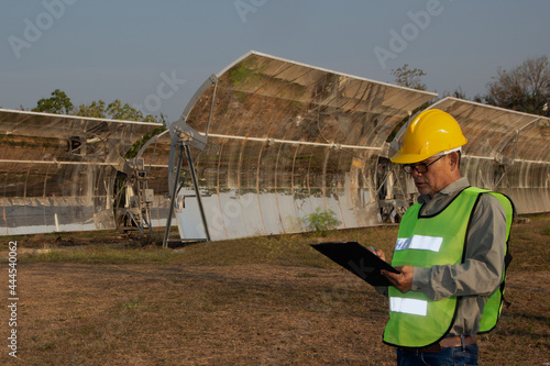 Tableau sur toile The Asian engineer staff in uniforms and helmets are checking and recording in the journal of the parabolic solar rail