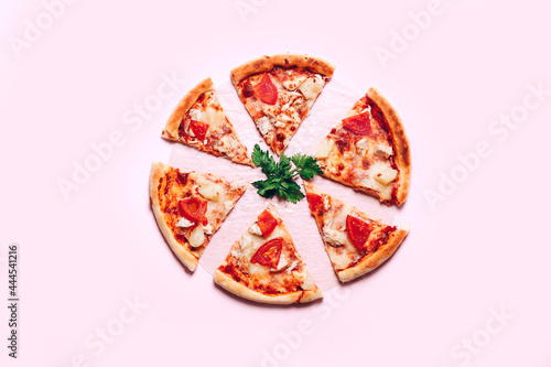 Top view with a sliced pizza on pink background.