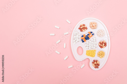 Global Pharmaceutical Industry and Medicinal Products - Diferent Colorful Pills, Tablets and Capsules on White Art Palette Lying on Pink Background, Flat Lay