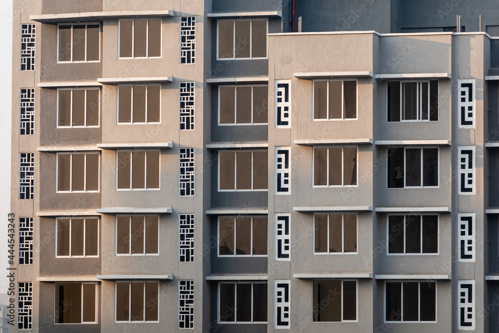 Windows on the exterior facade of a grey modern concrete high rise apartment building in suburban Mumbai. Windows on the exterior facade of a grey modern concrete high rise apartment building in suburban Mumbai.