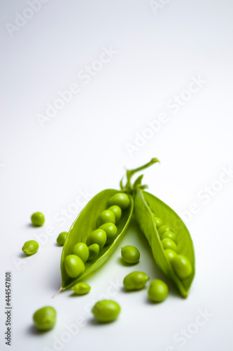 Green peas in pods on a white background, healthy vegetarian food.