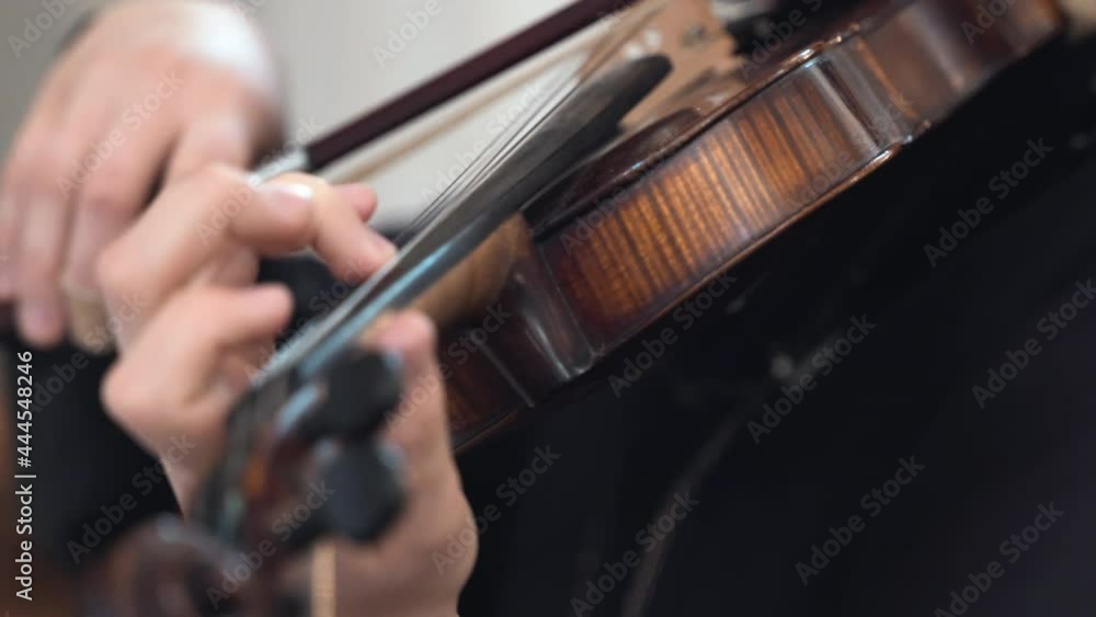 Cinematic close-up shot of nun playing the violin in church during religious ceremony, religious sister performing chorus songs playing violin. Violinist devoting musical performance to God Jesus Cinematic close-up shot of nun playing the violin in church during religious ceremony, religious sister performing chorus songs playing violin. Violinist devoting musical performance to God Jesus