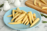 Fresh baby corn cobs on white marble table