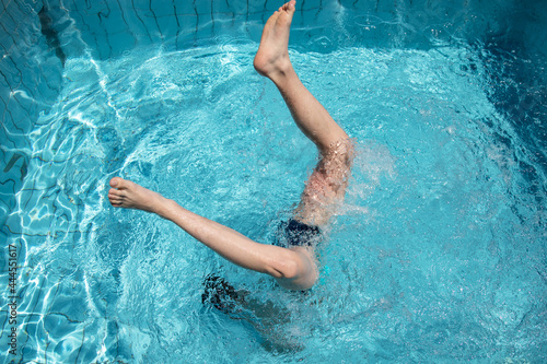 Swimming in the hotel pool. A young man dives into the pool at the hotel.