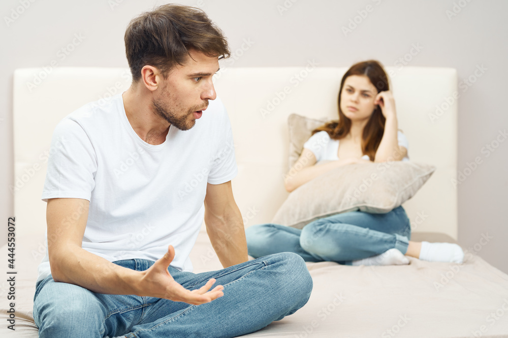 young couple in the bedroom on the couch communication conflict quarrel young couple in the bedroom on the couch communication conflict quarrel