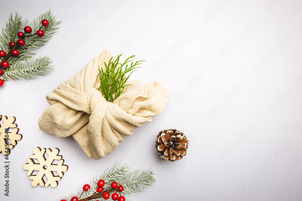 Zero waste gift wrapping traditional Japanese furoshiki style. Plastic free hand made gift package for Christmas with christmas decorations, top view Zero waste gift wrapping traditional Japanese furoshiki style. Plastic free hand made gift package for Christmas with christmas decorations, top view