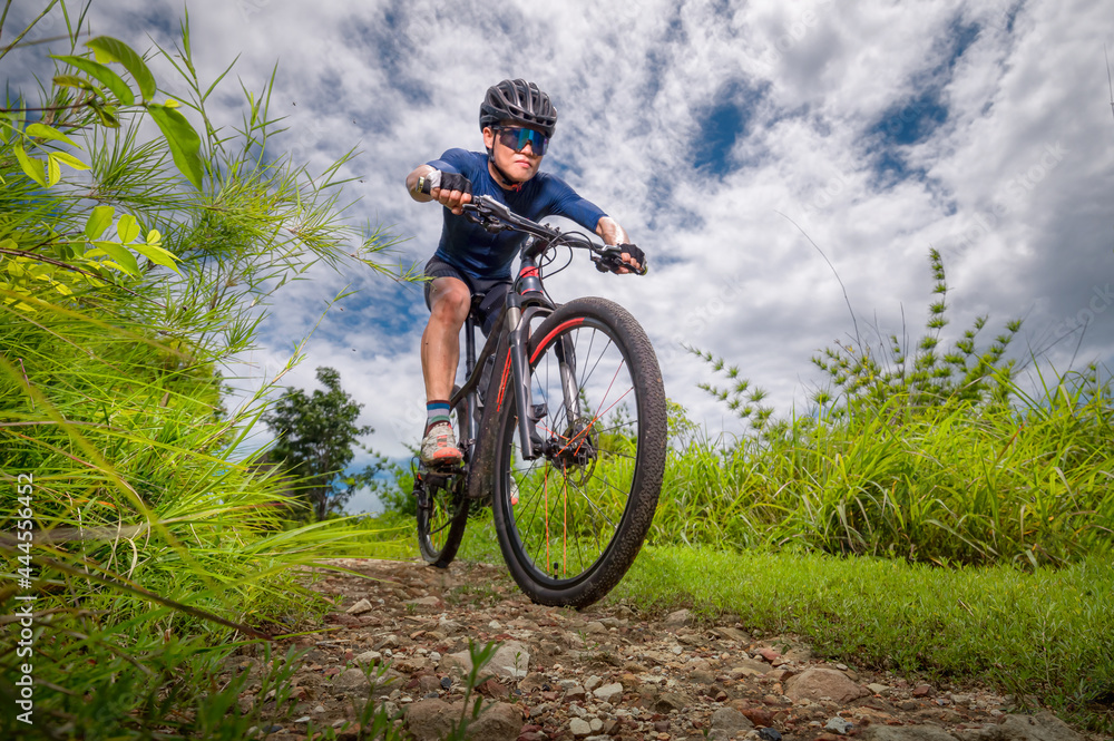 Mountain bikers ride MTB, mountain bike downhill to the extreme. Asian man rides MTB, mountain bike downhill in the wild to extremes. Extreme Sport and MTB, mountain bike downhill Concept. Mountain bikers ride MTB, mountain bike downhill to the extreme. Asian man rides MTB, mountain bike downhill in the wild to extremes. Extreme Sport and MTB, mountain bike downhill Concept.