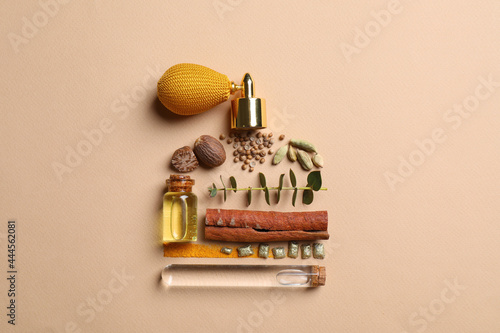 Photos Bottle of luxury perfume and different ingredients on beige background, flat lay