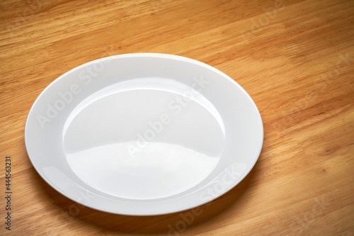 white empty cuisine tableware dish isolated on wooden dinner table in light and shade