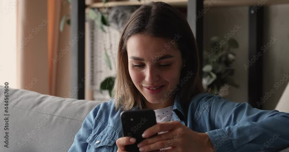 Head shot smiling young 20s woman using cellphone software applications, enjoying chatting in social network, shopping in online store, playing mobile games or web surfing, tech addiction concept. Head shot smiling young 20s woman using cellphone software applications, enjoying chatting in social network, shopping in online store, playing mobile games or web surfing, tech addiction concept.