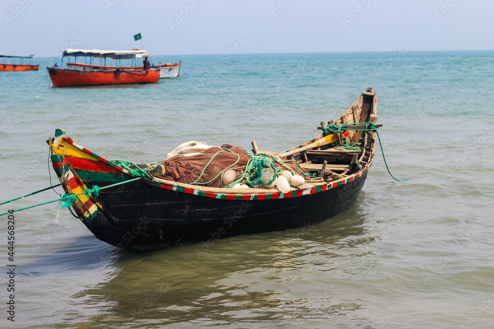 Bangladeshi traditional fishing boat on St. Martin's Island. Fisherman preparing boat for sailing into the ocean. Colorful fishing boats.