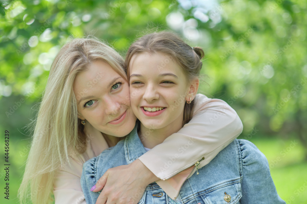 happy mother with her daughter hugging a teenager in the summer. Caring happy mother enjoy day with teenage girl child, laugh have fun. Mother giving her daughter advice. happy mother with her daughter hugging a teenager in the summer. Caring happy mother enjoy day with teenage girl child, laugh have fun. Mother giving her daughter advice.