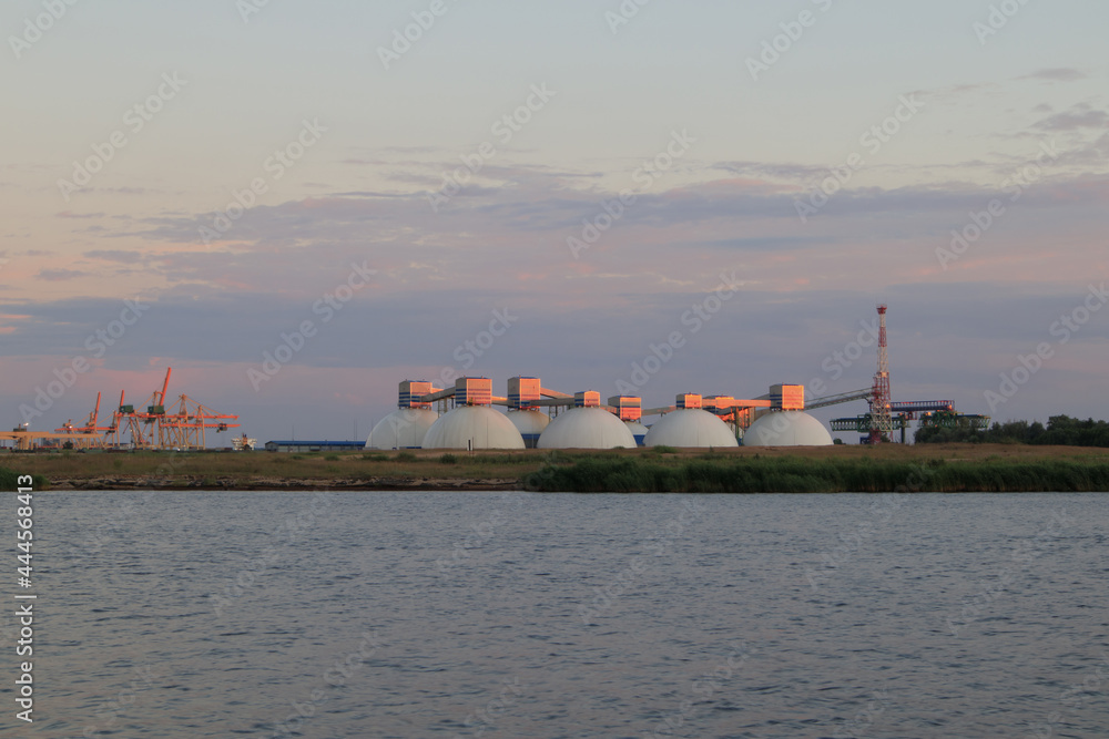 Fertilizer terminal in Riga, Latvia. Large warehouse on the bank of the river Daugava at sunset