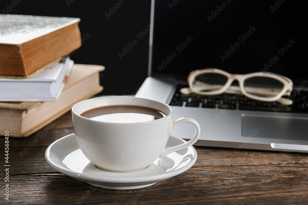 Cup of coffee and laptop on wooden table Cup of coffee and laptop on wooden table