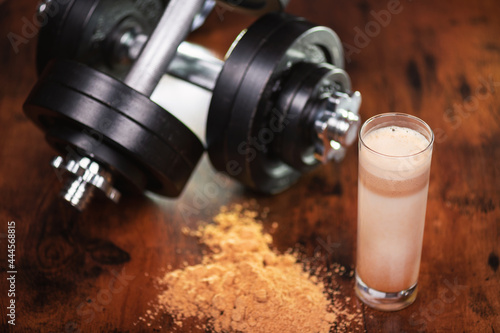 Protein-Shake mit Hanteln zum Kraftsport