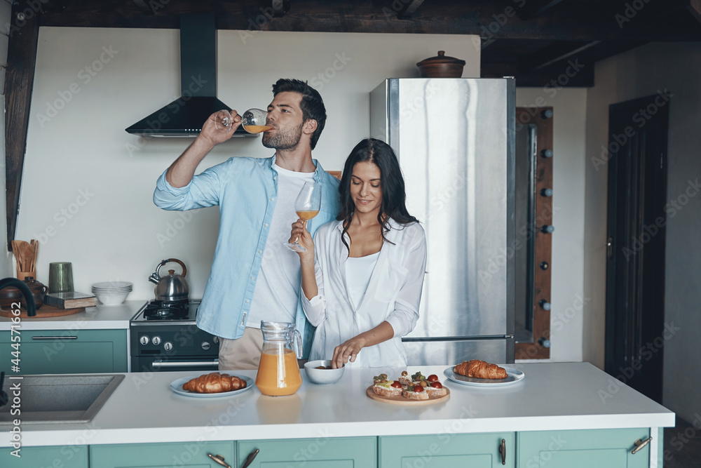 Beautiful young couple preparing breakfast while spending time in the kitchen