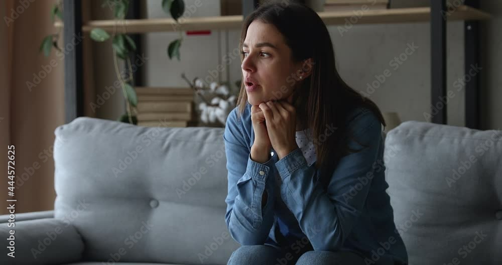 Unhappy frowning stressed young 20s woman worrying about wrong decision or feeling jealous alone at home, sitting on sofa, regretting mistakes, thinking of health problems or relationship troubles. Unhappy frowning stressed young 20s woman worrying about wrong decision or feeling jealous alone at home, sitting on sofa, regretting mistakes, thinking of health problems or relationship troubles.