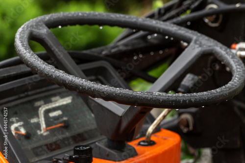 A wet steering wheel of mini truck outdoor on a rainy day photo