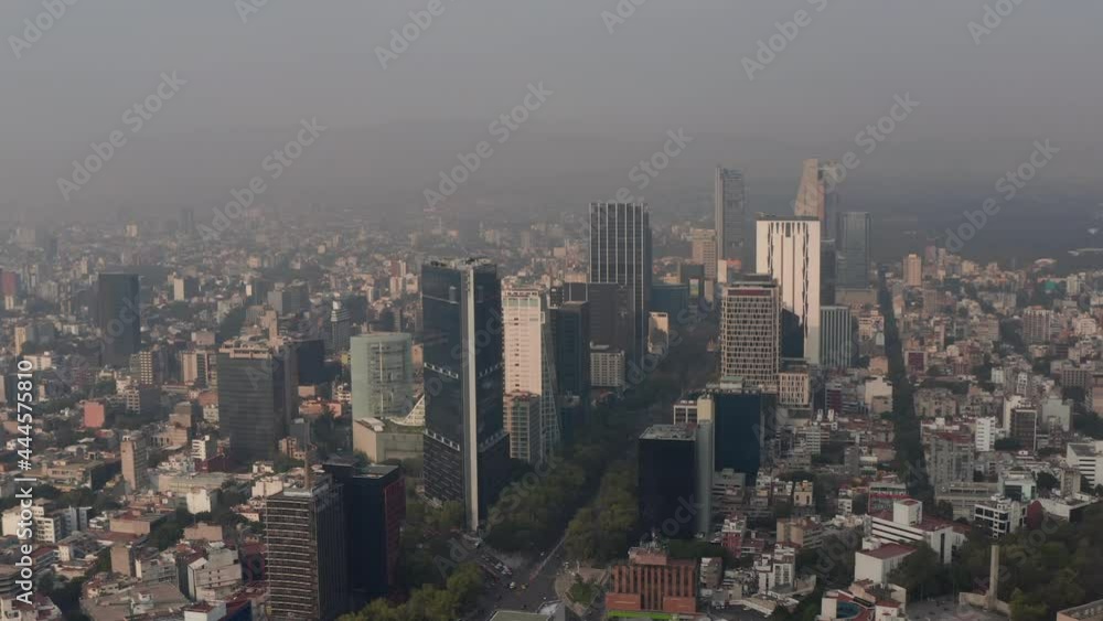 Elevated panning view of tall office building in downtown. Limited visibility due to air pollution. Orbiting around group of skyscrapers. Mexico City, Mexico. Elevated panning view of tall office building in downtown. Limited visibility due to air pollution. Orbiting around group of skyscrapers. Mexico City, Mexico.