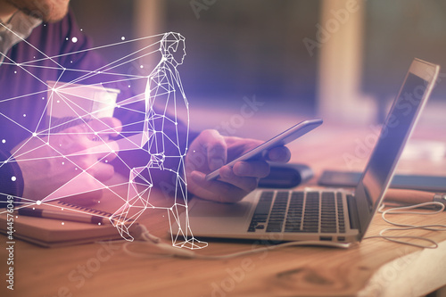 Double exposure of man's hands holding and using a mobile device and creative hologram drawing.