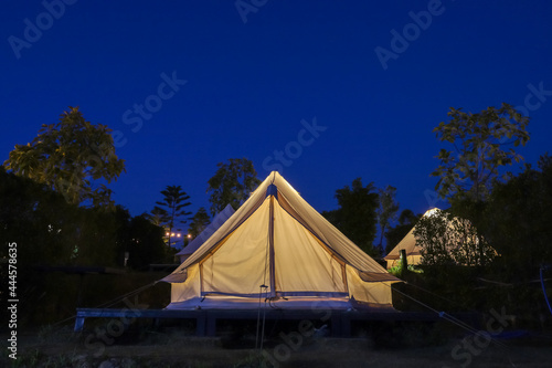 The white tent is camping in the garden at night