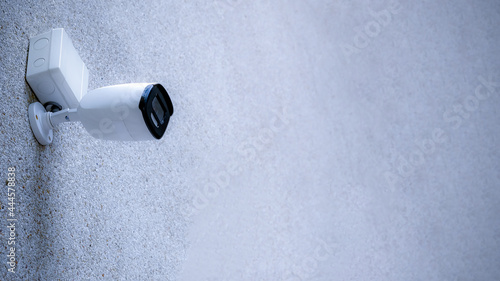 CCTV camera on a wall. A blurred night cityscape background. lungs separated, IP CCTV camera install by have water proof cover. photo