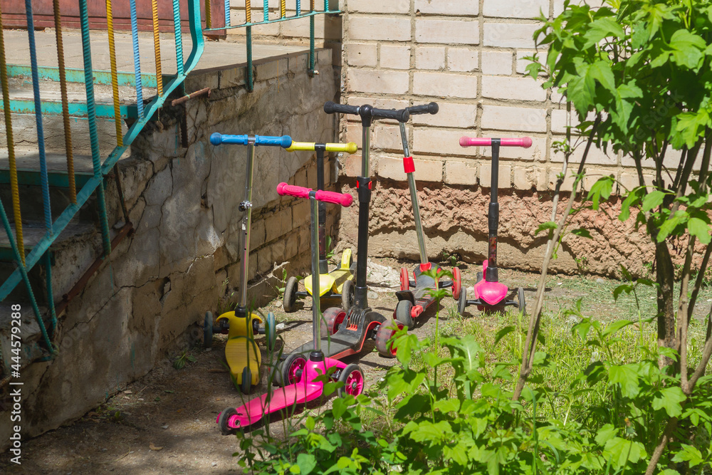 Children's scooters are parked at the entrance to the kindergarten, the children arrived on colorful scooters Children's scooters are parked at the entrance to the kindergarten, the children arrived on colorful scooters