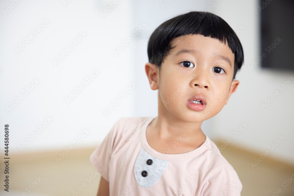 Close-up portrait Asian child boy straight black hair wearing a light brown shirt looking at camera of him make funny faces of happy smiling. Advertising childrens products Close-up portrait Asian child boy straight black hair wearing a light brown shirt looking at camera of him make funny faces of happy smiling. Advertising childrens products