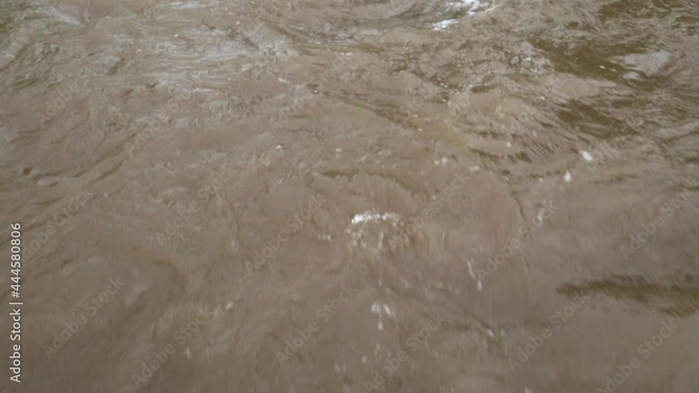 Close up shot of a muddy raging torrents of water that moving with great speed Close up shot of a muddy raging torrents of water that moving with great speed