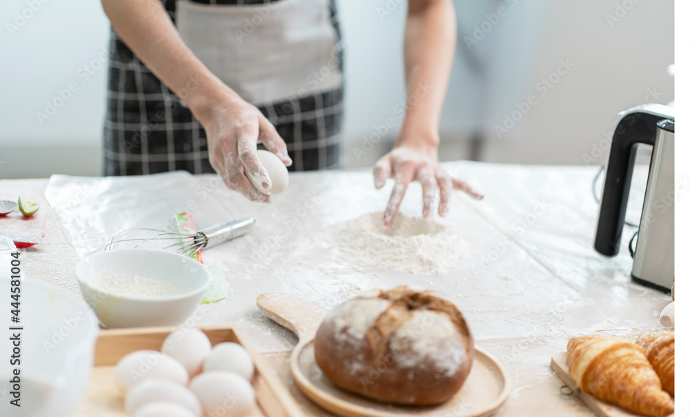 Hands knead the dough to make homemade cakes in the kitchen. 