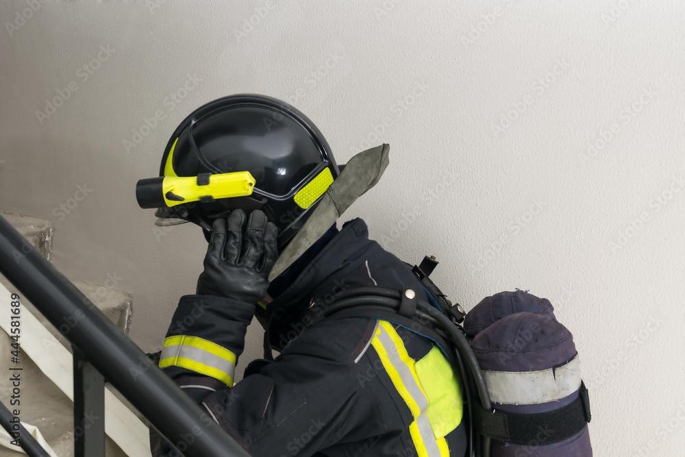 a firefighter in a helmet climbs the stairs, close-up a firefighter in a helmet climbs the stairs, close-up