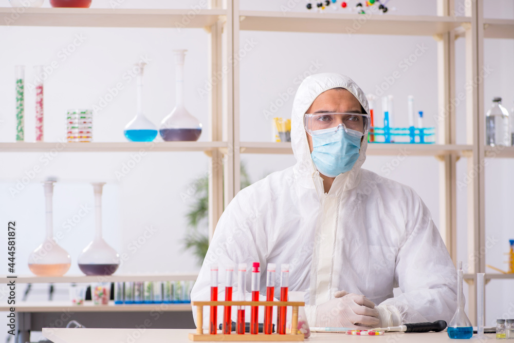Young male chemist in drugs syntesis concept Young male chemist in drugs syntesis concept