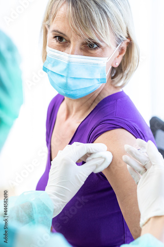 Women wearing masks getting vaccinated. Concept of coronavirus, vaccination elderly woman mask who approved covid-19 vaccination at hospital. Female doctor immunizes elderly patients against the virus