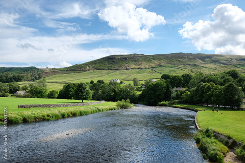 A view looking south along the River Wharfe toward Burnsall and Thorpe Fell, in the Yorkshire Dales, North Yorkshire. photo