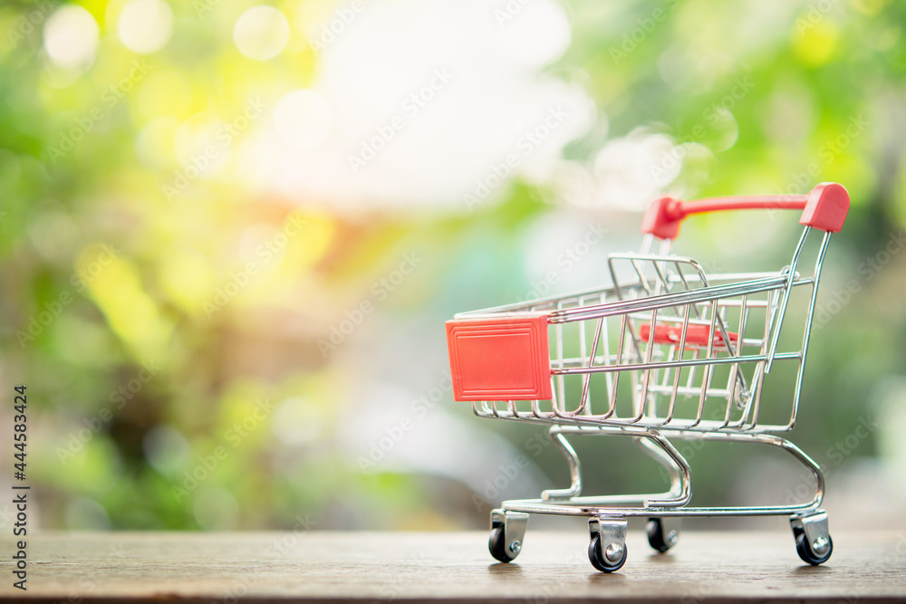 Shopping concept - empty shopping cart or trolley on brown wood table. online shopping consumers can shop from home and delivery service. with copy space Shopping concept - empty shopping cart or trolley on brown wood table. online shopping consumers can shop from home and delivery service. with copy space