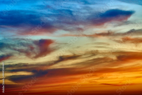 Colorful clouds in the blue summer sky at sunset time. Abstract nature background.