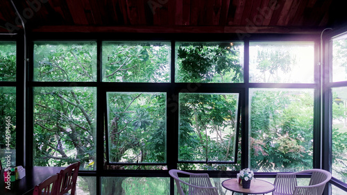 Landscape view from the window for relaxing time, Window interior design with green plant ouside, Flare light through the window in the morning