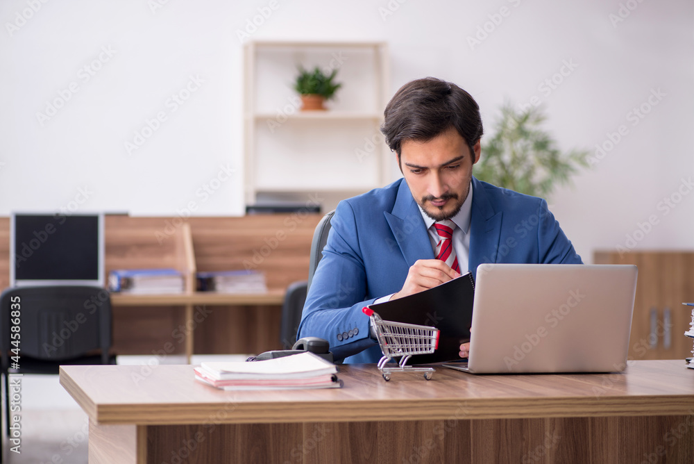 Young male employee in e-commerce concept at workplace Young male employee in e-commerce concept at workplace