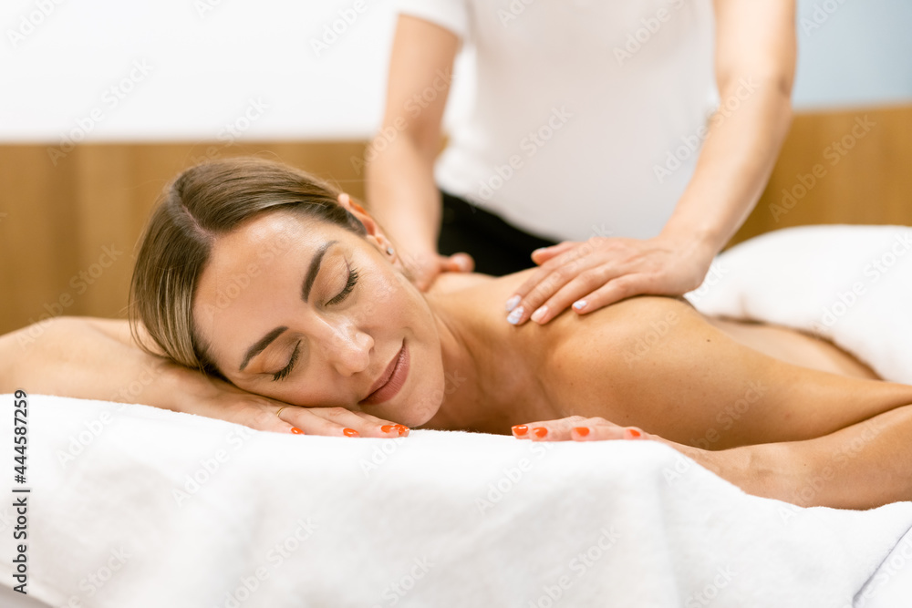 Middle-aged woman having a back massage in a beauty salon.