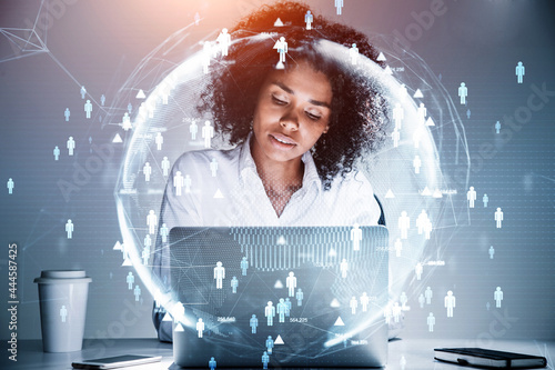 Obraz na plátně African American businesswoman sitting at the table and working on laptop conducting a research to hire high qualified employees for international projects