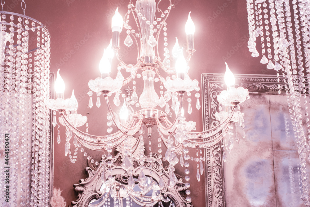 Fotografie Crystal chandelier close-up. pink light. Selective focus.