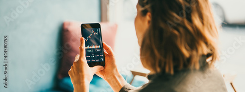 Принти на полотні Woman using mobile phone investing application