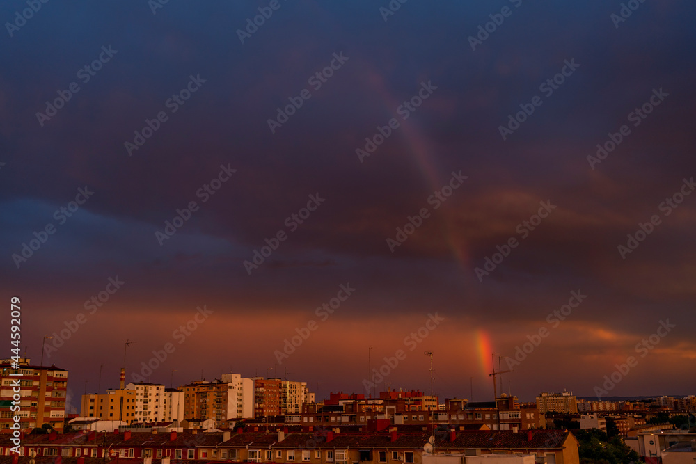 Rainbow in the city of Zaragoza after rain on a hot summer day due to high temperatures due to climate change, Spain