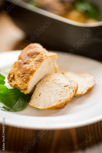baked chicken fillet pieces with spices and herbs, in a ceramic form