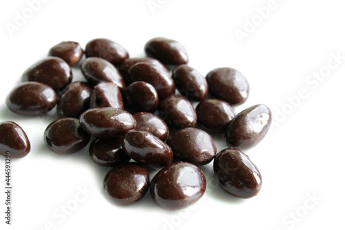 dark chocolate covered raisin drops on white background