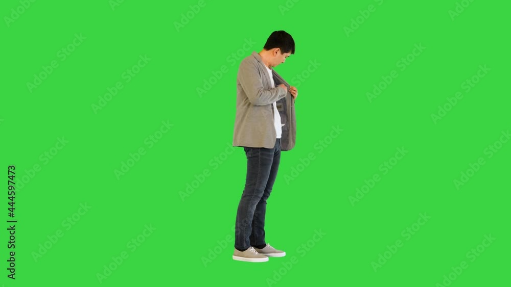 Young asian man counts money and puts them into pocket on a Green Screen, Chroma Key. Young asian man counts money and puts them into pocket on a Green Screen, Chroma Key.