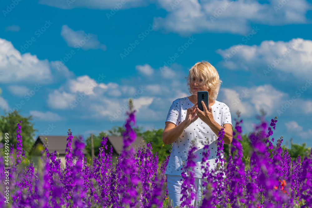 Outdoor portrait of a beautiful happy middle aged blonde woman in a field with flowers Outdoor portrait of a beautiful happy middle aged blonde woman in a field with flowers